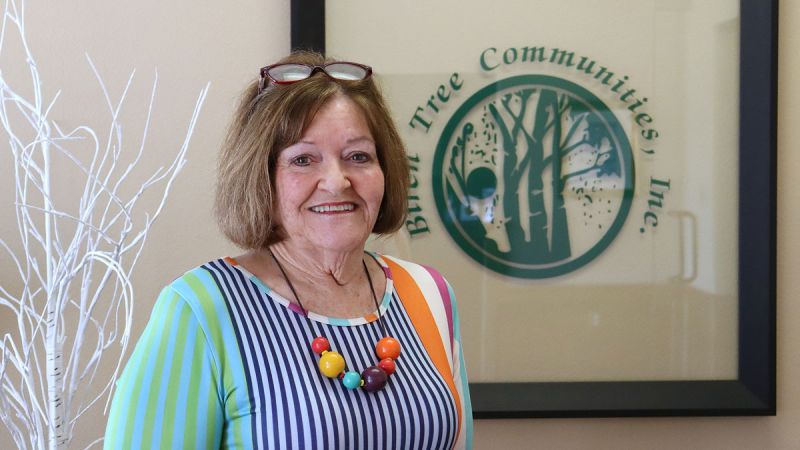 Cindy Slaughter in front of Birch Tree Communities logo sign